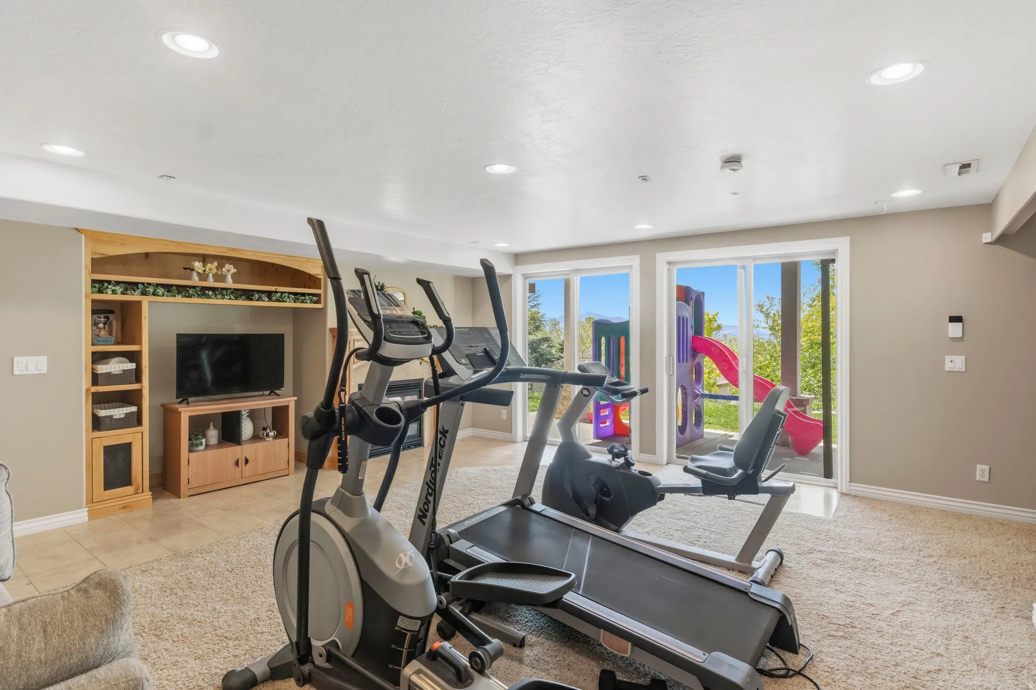 Lower level recreation room featuring recessed lighting and a built-in entertainment center with wood-finish cabinetry