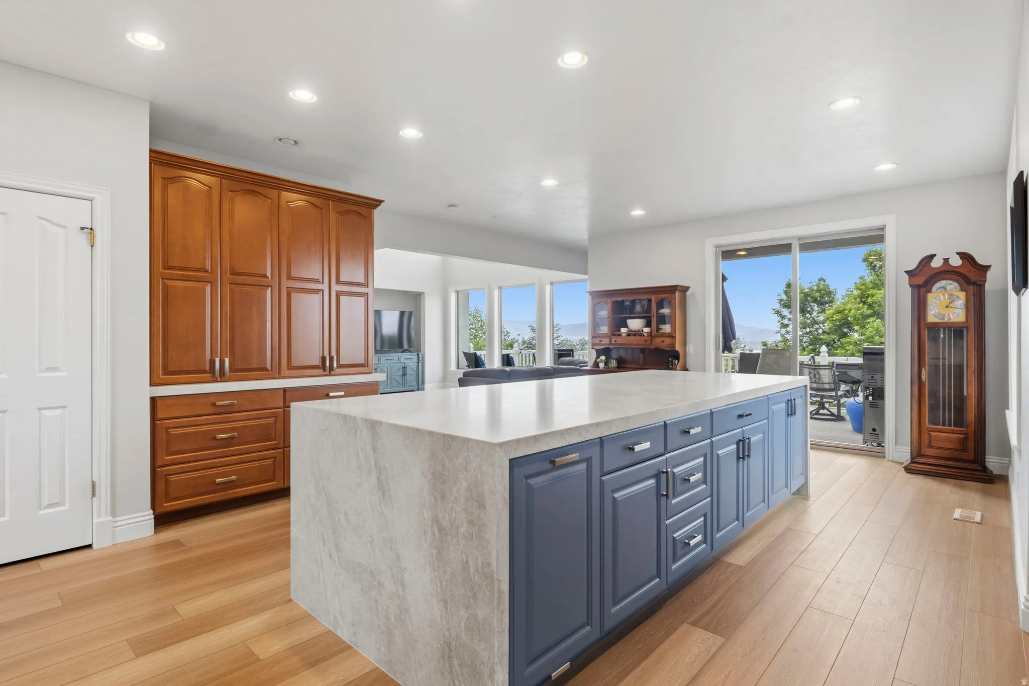 Spacious kitchen featuring a large central island with blue cabinetry and a light-toned countertop