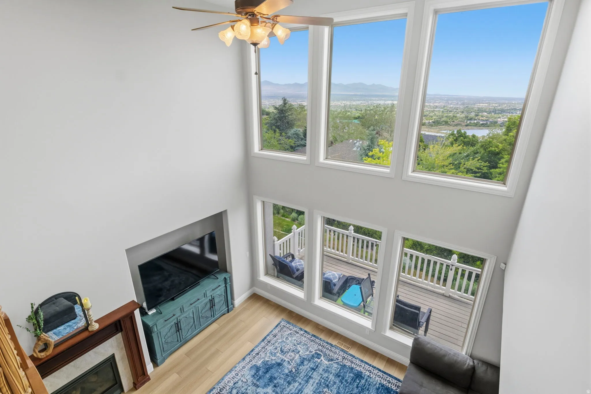 Two-story living area featuring a wood-finish floor and a fireplace with a wood mantle