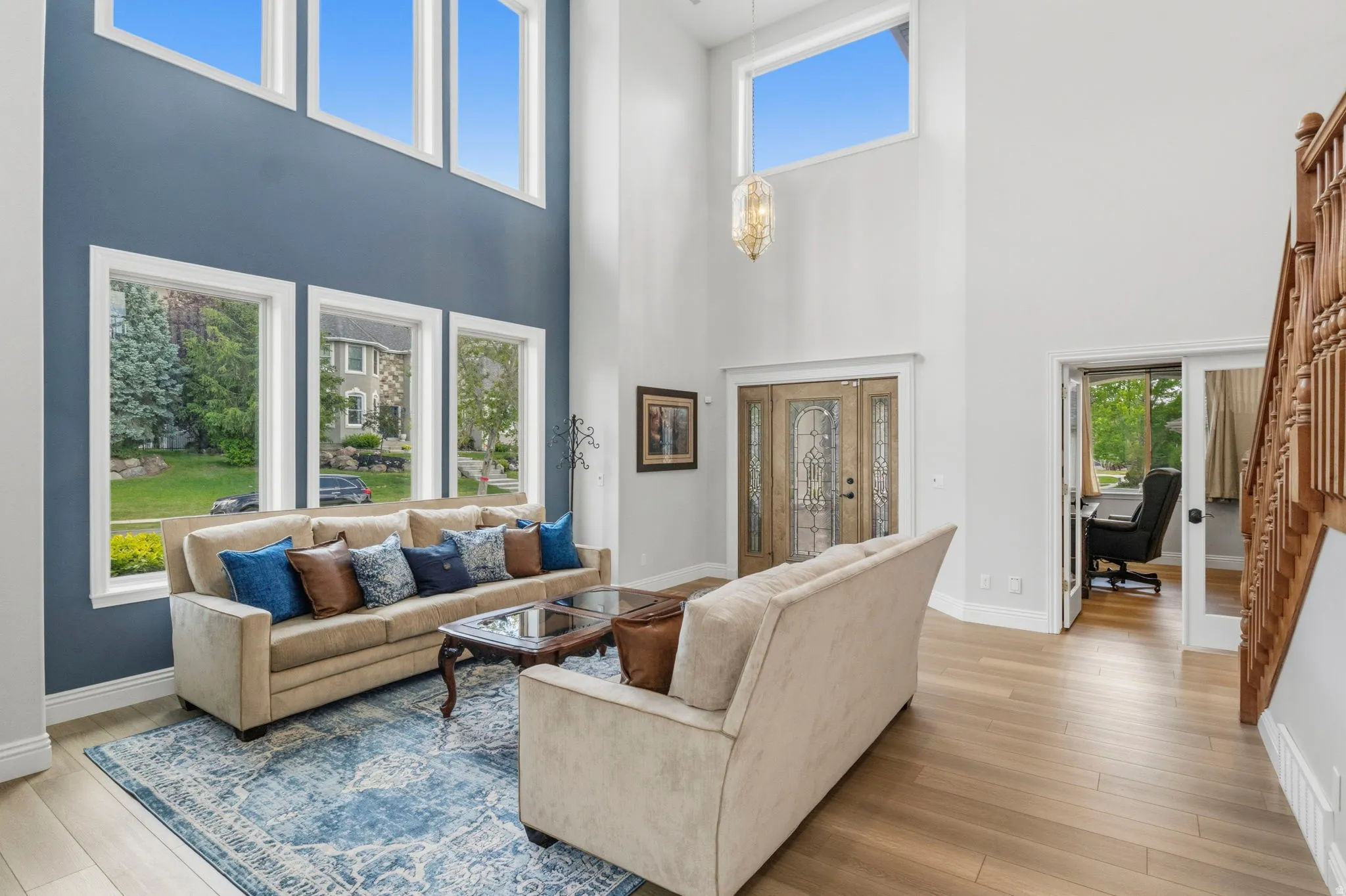 Two-story living area featuring a vaulted ceiling and an array of tall windows