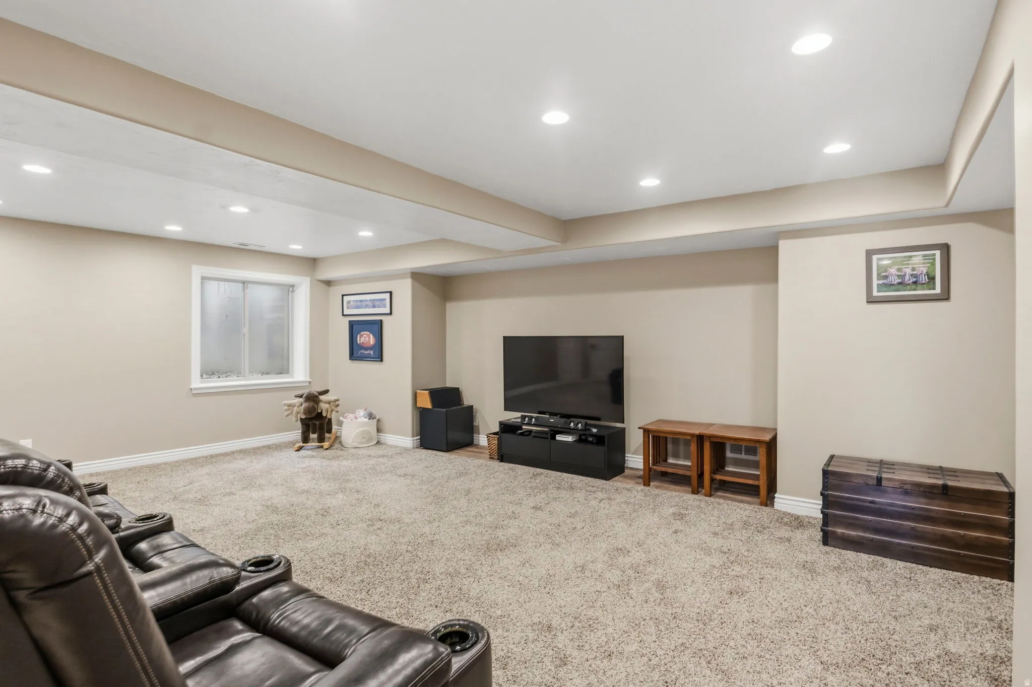Spacious carpeted room featuring recessed lighting, painted walls, and a visible window