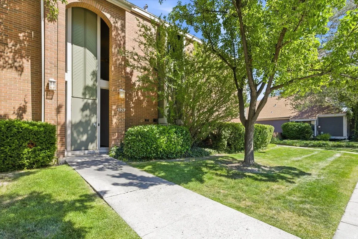 Brick exterior featuring an arched entryway with a tall window panel