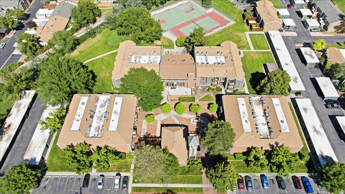Spacious complex featuring multiple residential buildings, ample surface parking, and a central courtyard