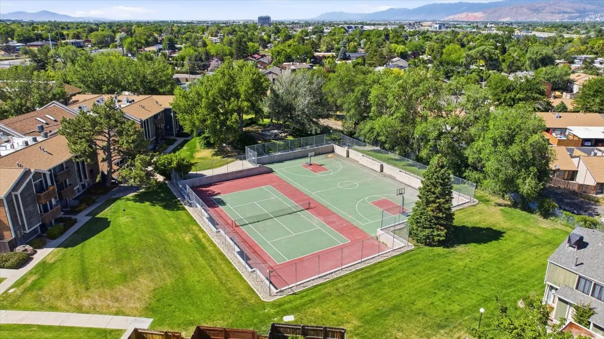 Outdoor sport court featuring a basketball hoop and a tennis court