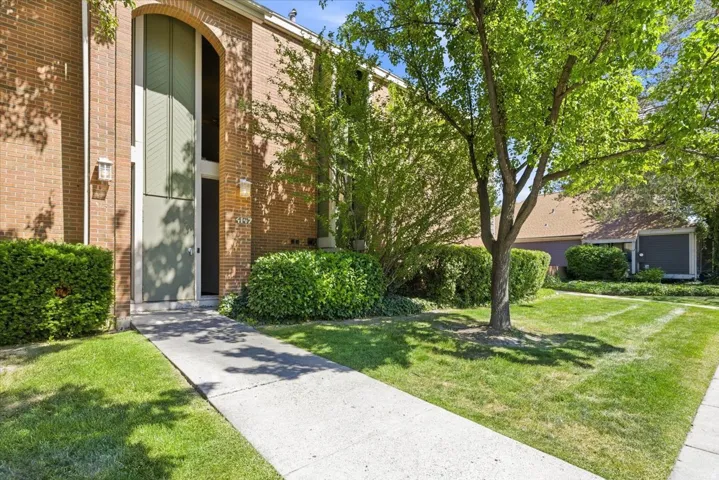 Brick exterior featuring an arched entryway with a tall window panel