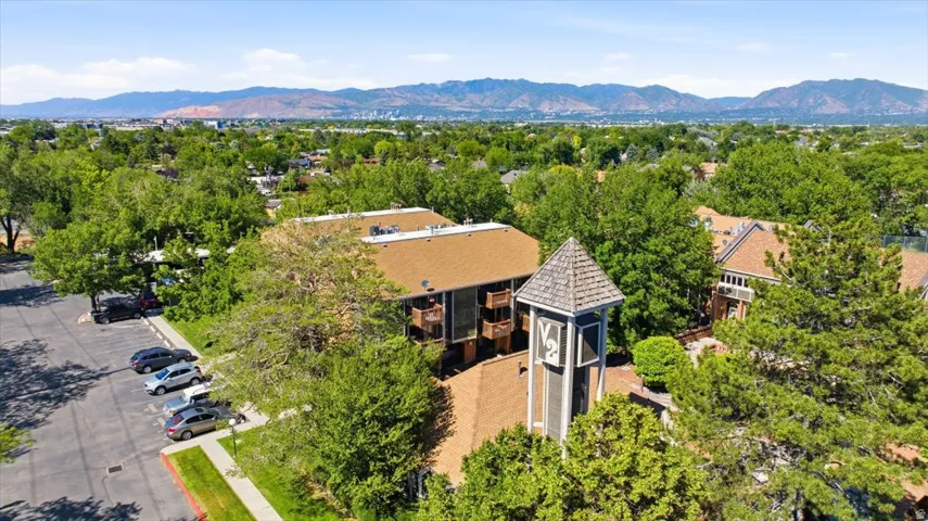 Property featuring a central tower with a shingled roof, surrounded by mature trees