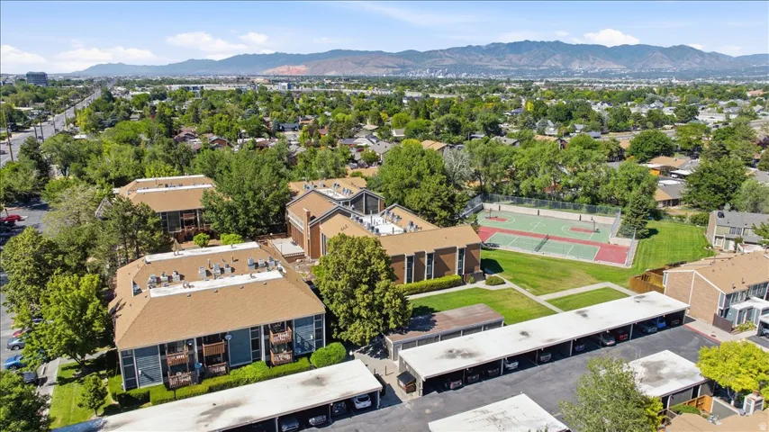 Multi-building complex featuring covered parking, mature landscaping, and an on-site sports court
