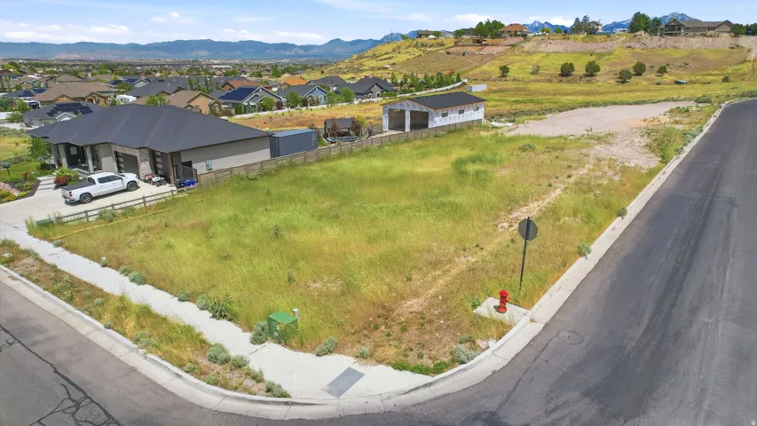 Corner lot with a paved street frontage, sidewalk, and existing utilities