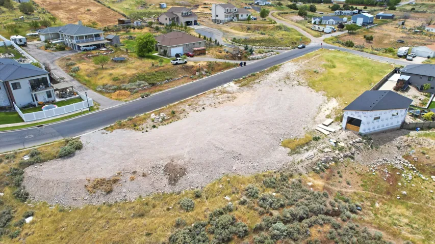 Graded lot with partial foundation and new construction framing, featuring a paved road frontage