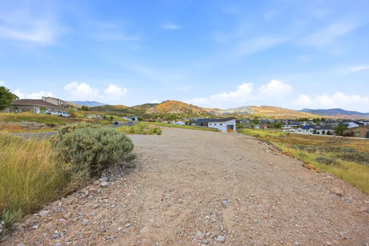 Expansive gravel lot with surrounding natural landscaping