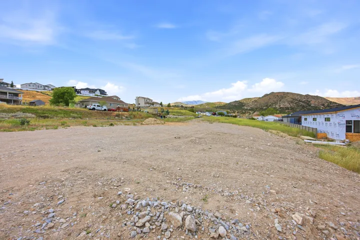 Expansive open lot featuring a level building area, surrounding natural landscape, and distant mountain scenery