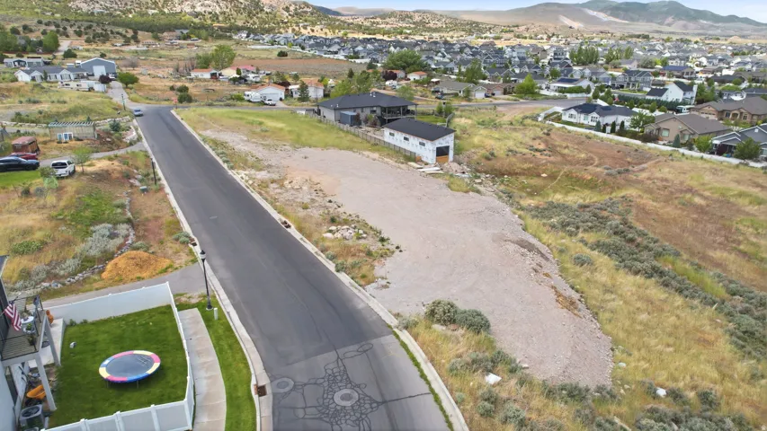 Expansive undeveloped lot featuring a gravel pad and natural shrubbery