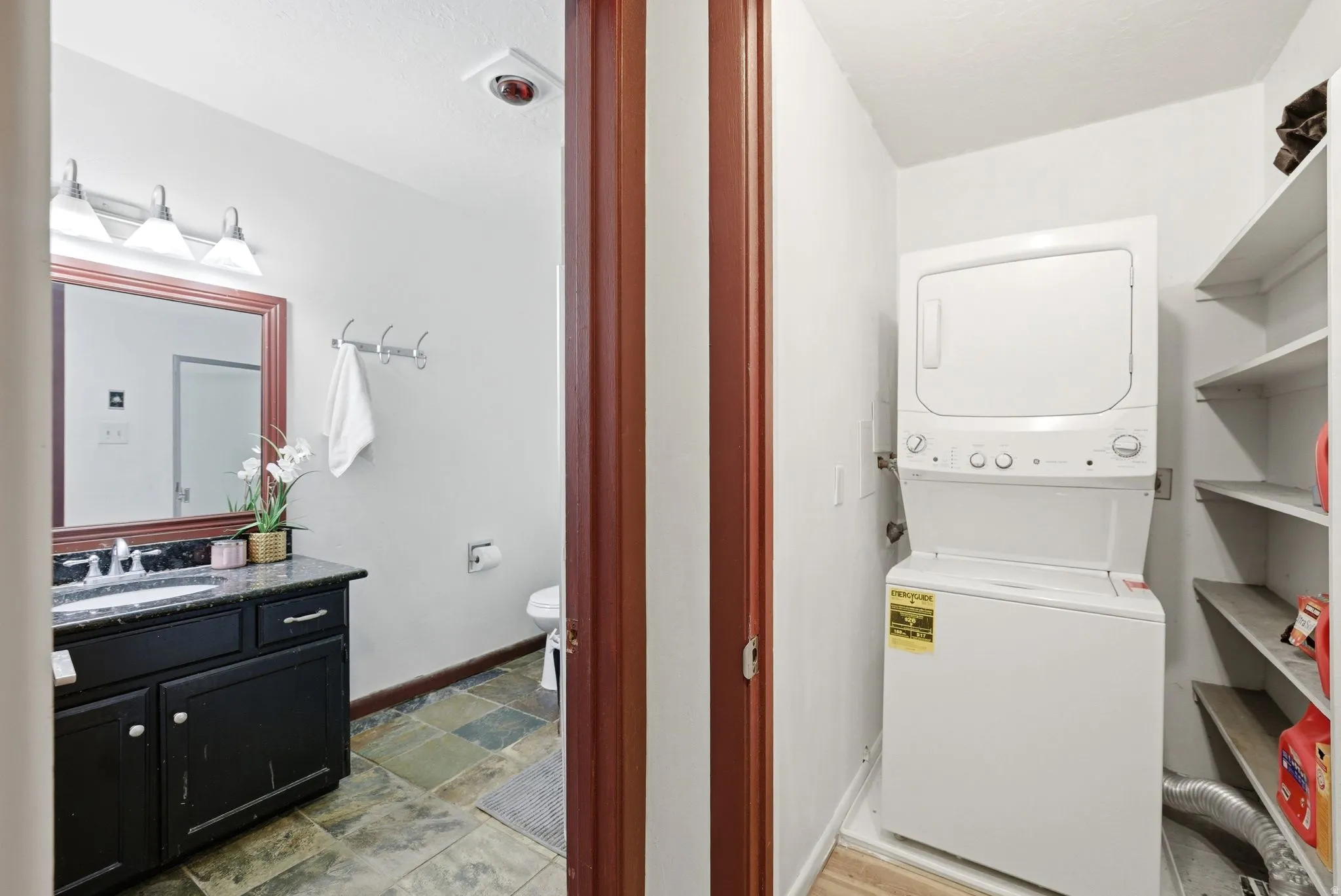 Bathroom featuring a dark wood vanity with a stone countertop and a rectangular mirror