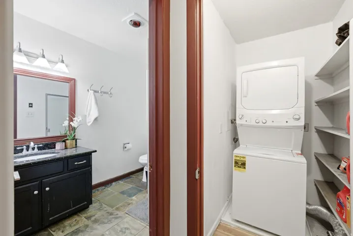 Bathroom featuring a dark wood vanity with a stone countertop and a rectangular mirror