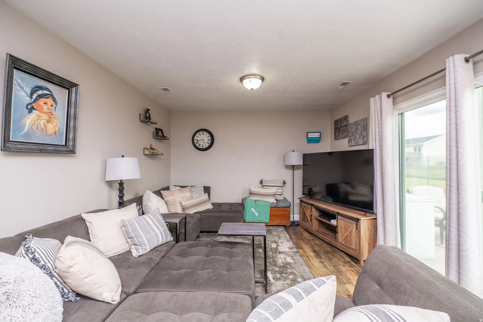 Living area featuring light neutral wall paint, wood-finish flooring, recessed lighting, and sliding glass door access to the exterior