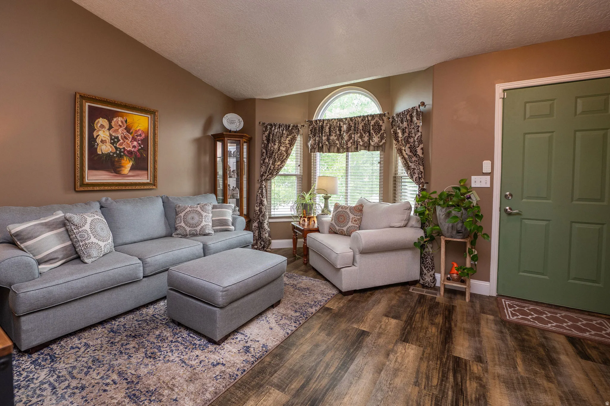Vaulted ceiling interior featuring warm neutral wall tones and wood-finish flooring