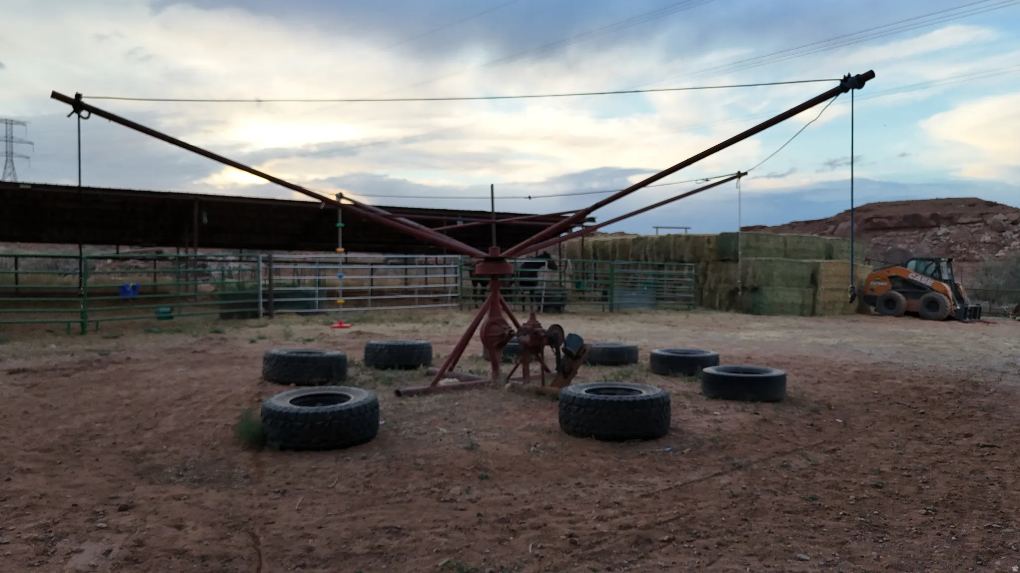 Outdoor recreational structure with a central rotating mechanism and surrounding tires