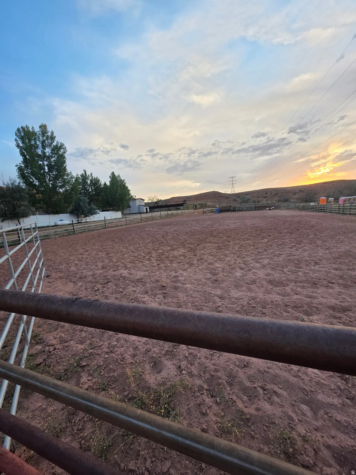 Expansive outdoor arena featuring a dirt surface and perimeter fencing
