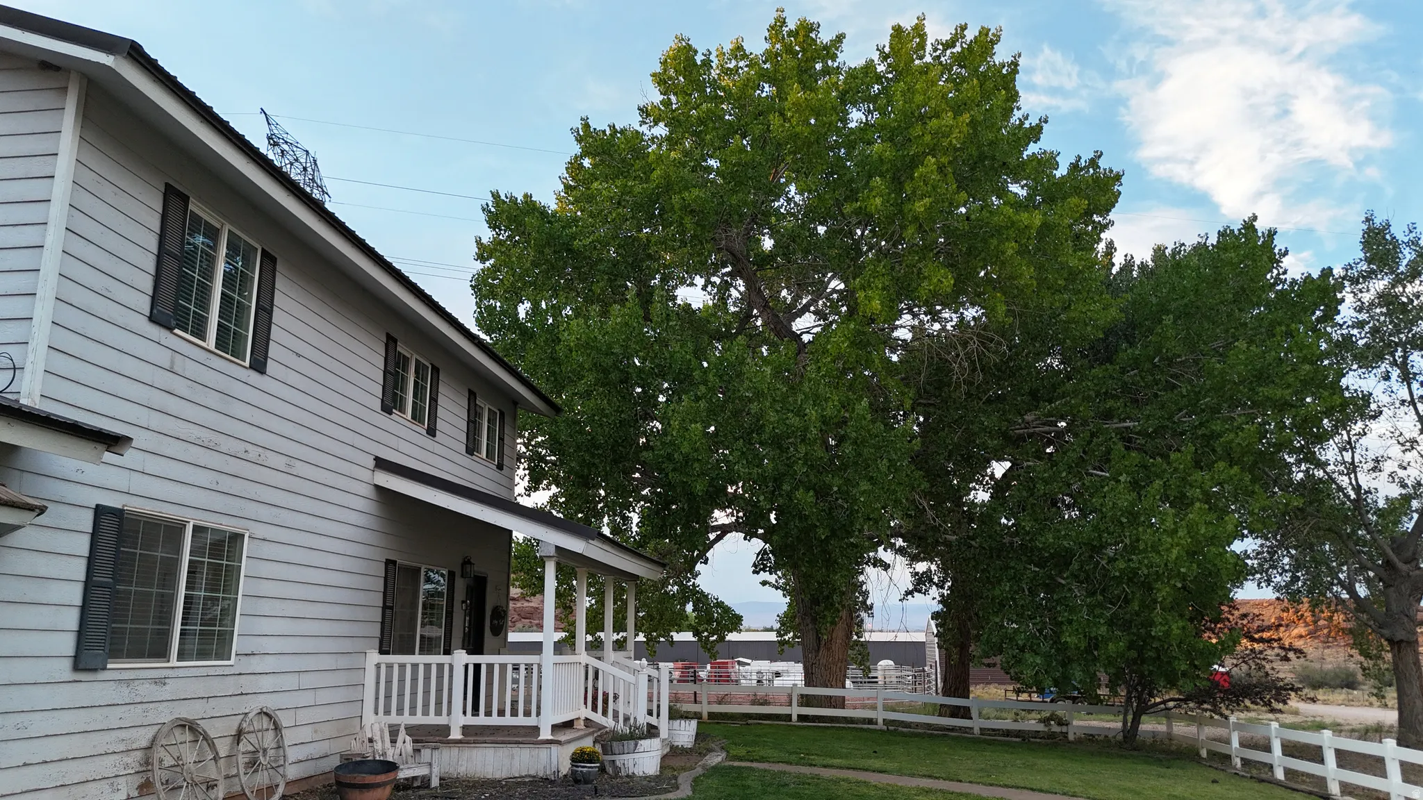 Two-story residence featuring light-colored horizontal siding and dark contrasting shutters