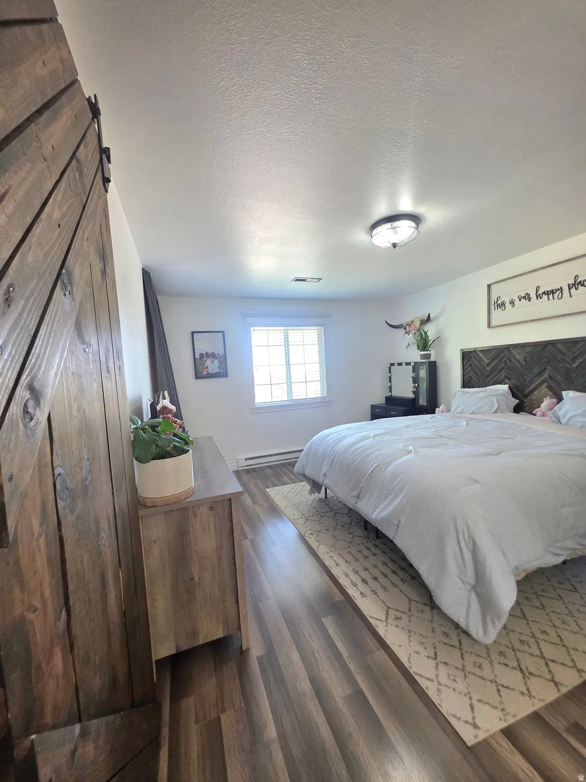 Interior space featuring wood-finish flooring, a window, and a ceiling-mounted light fixture