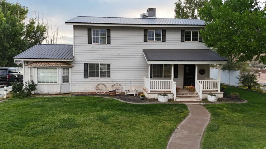 Two-story residence featuring a gray exterior siding and a dark metal roof
