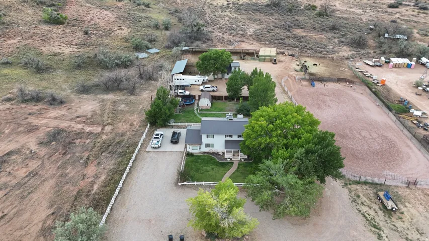 Expansive property featuring a two-story residence with a light-colored exterior and mature trees