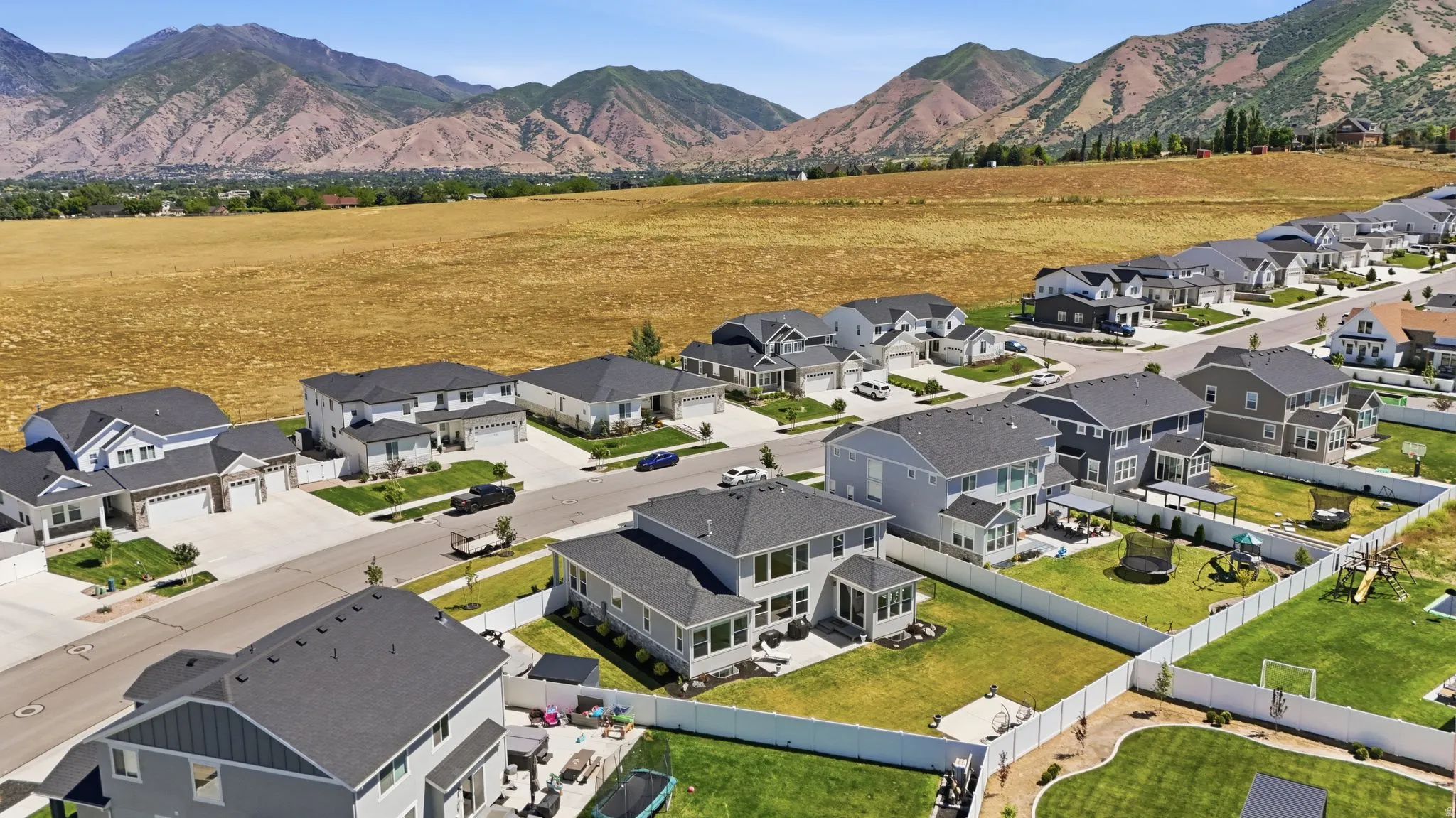 Expansive residential development featuring contemporary homes with dark shingle roofs