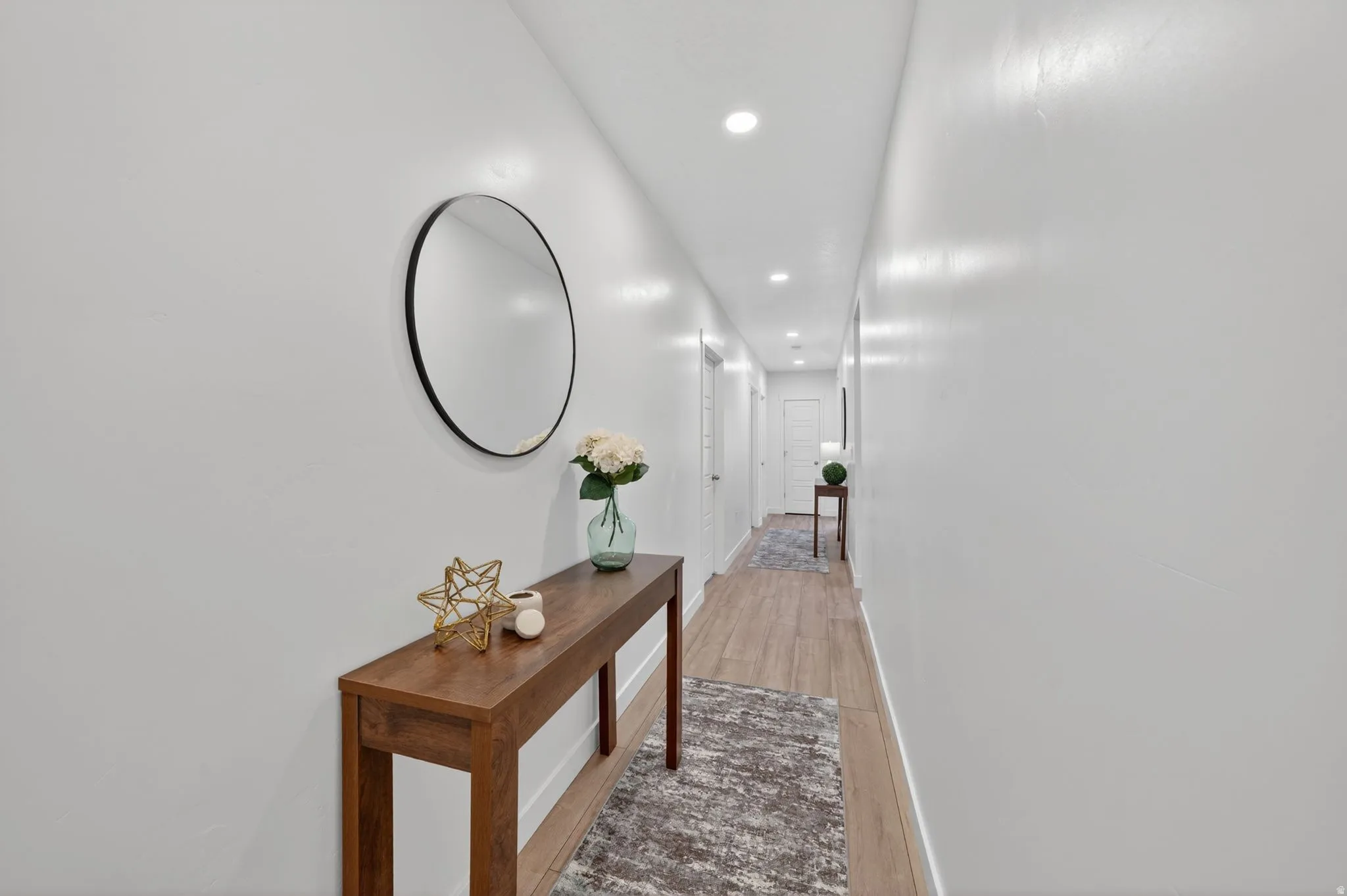 Hallway featuring wood-finish flooring, recessed lighting, and white paneled doors