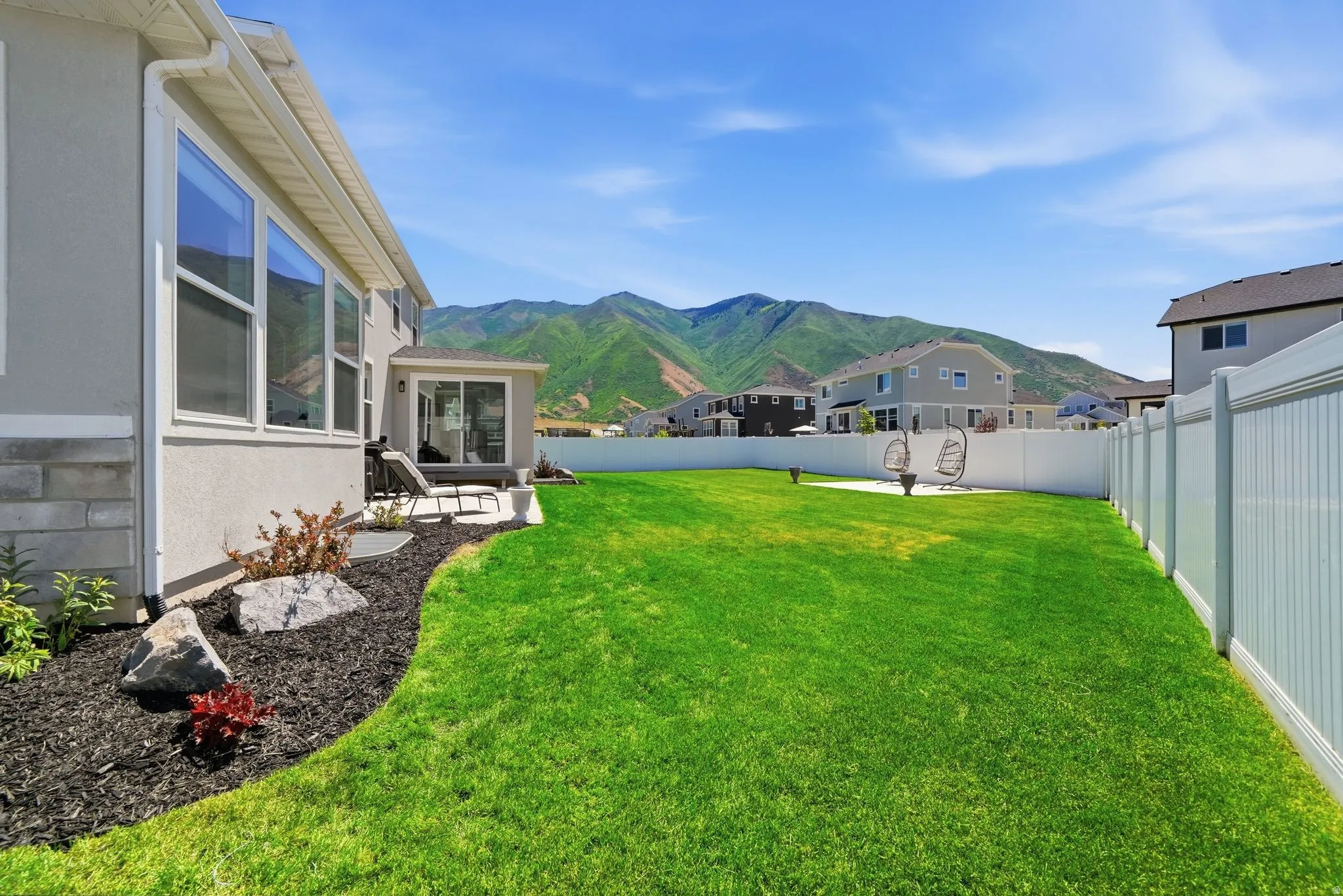 Expansive green lawn bordered by a white privacy fence