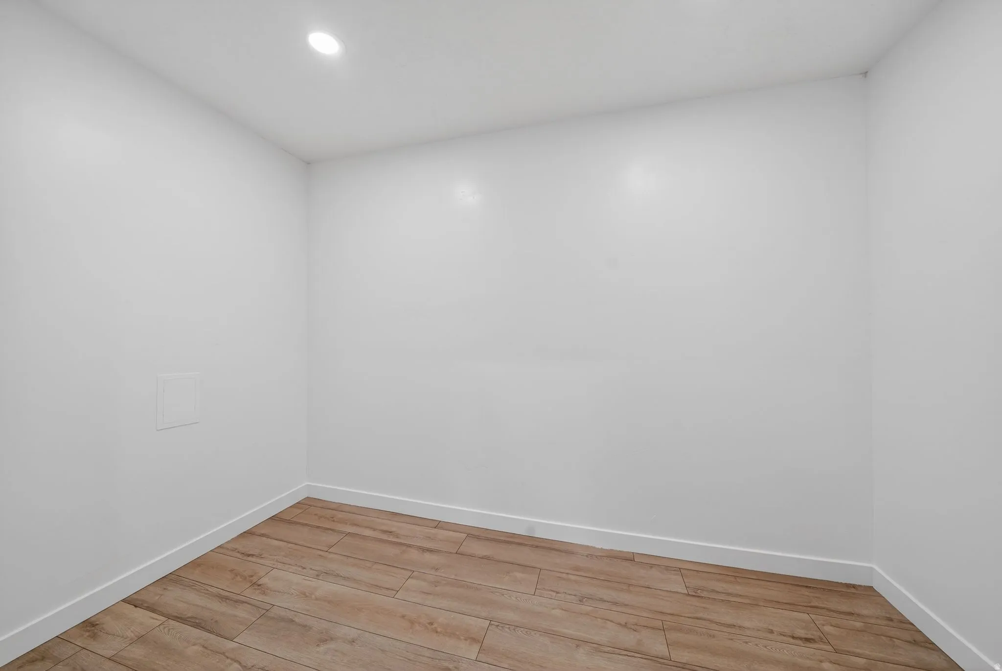 Room featuring recessed ceiling lighting, light wood-finish flooring, and white baseboards