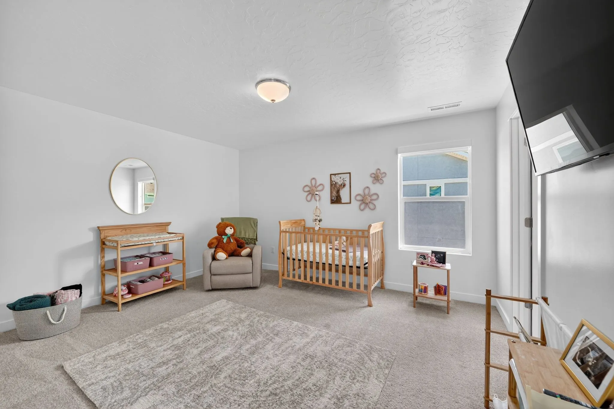 Spacious room featuring light gray carpet, white walls, and a single window with a white frame