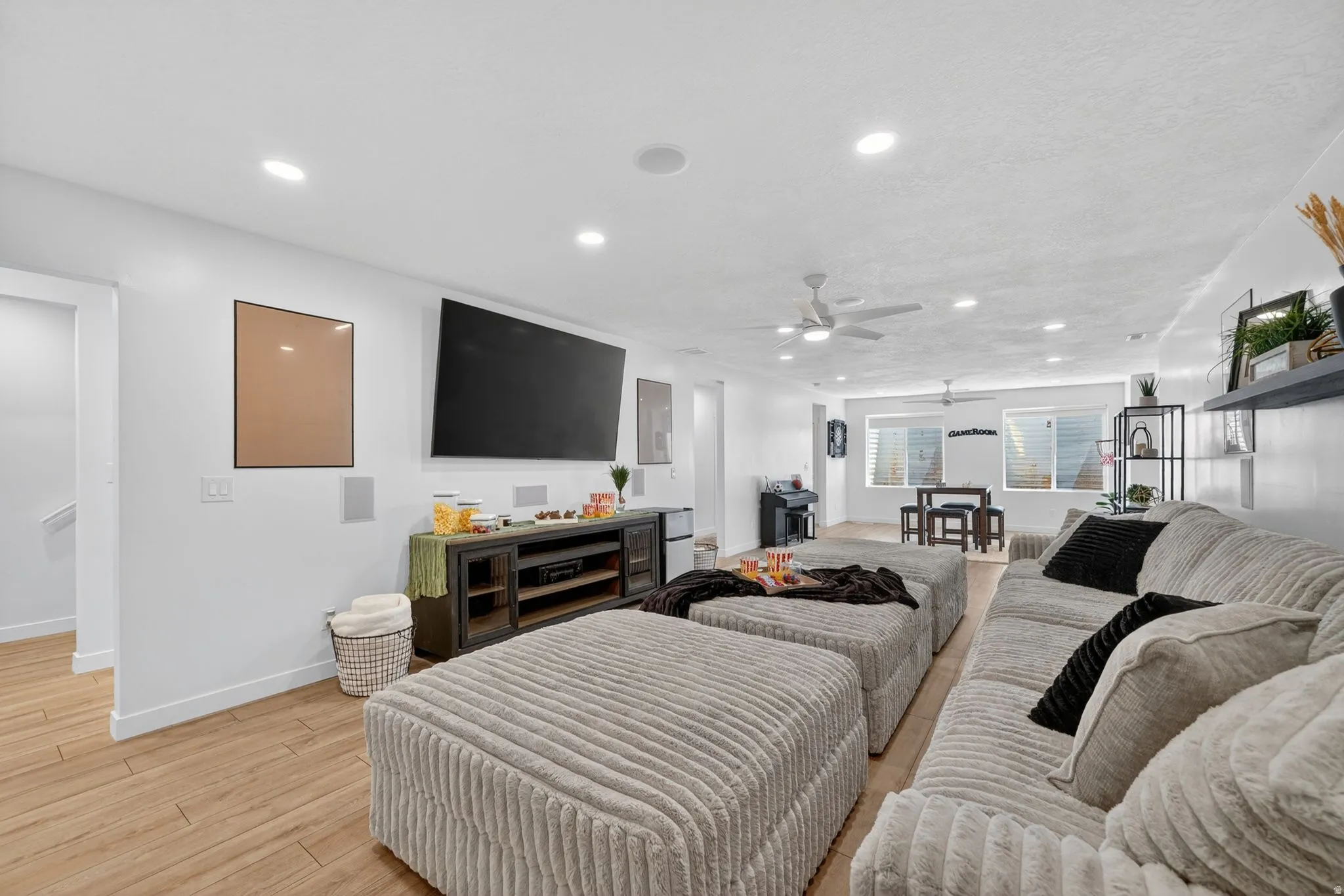 Open-concept living area featuring wood-finish flooring, recessed lighting, and a ceiling fan