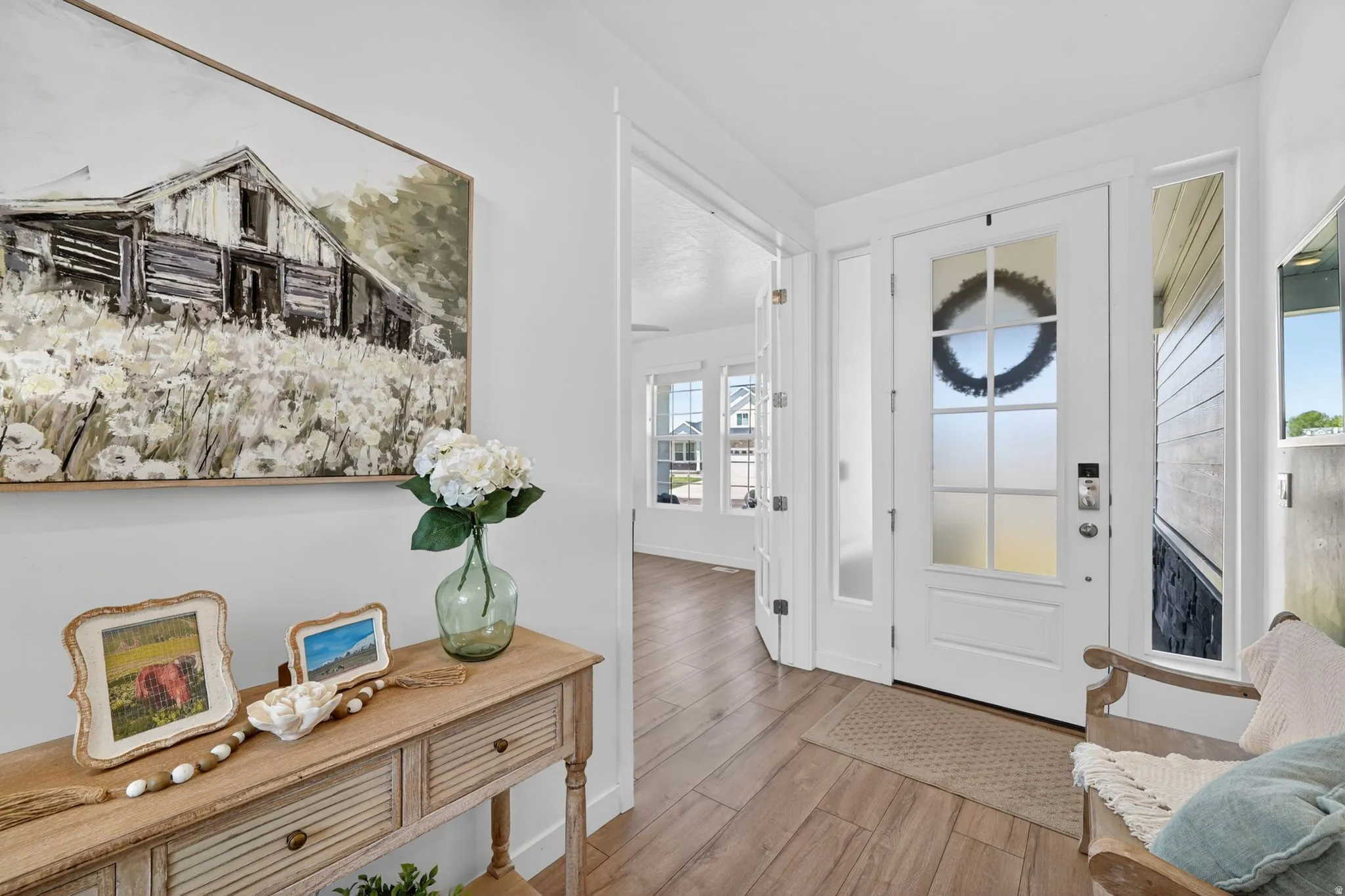 Entryway featuring a solid core door with frosted glass panels, a full-length sidelight, and wood-finish flooring