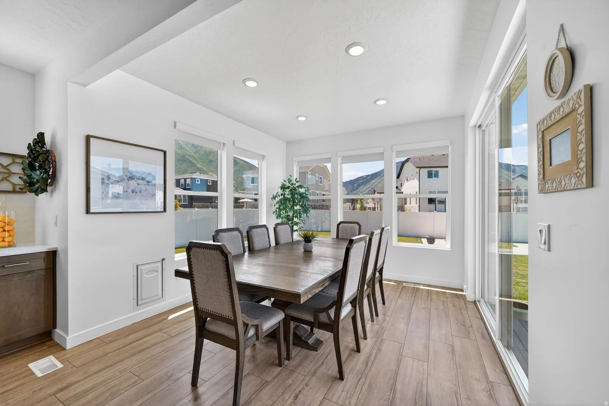 Dining area featuring a large wood-finish table, recessed lighting, and wood-look plank flooring