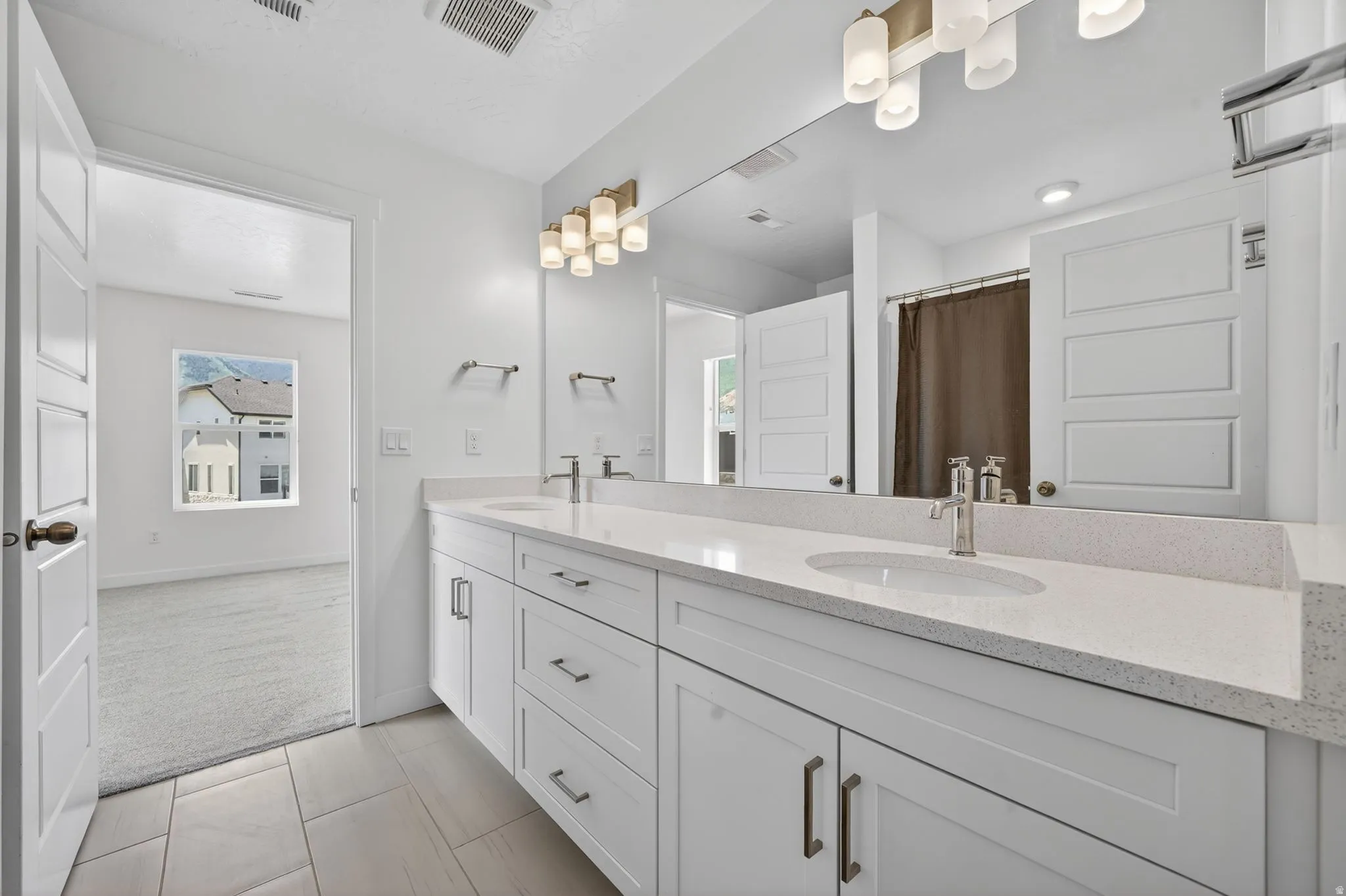 Double vanity with white cabinetry and light-toned countertops