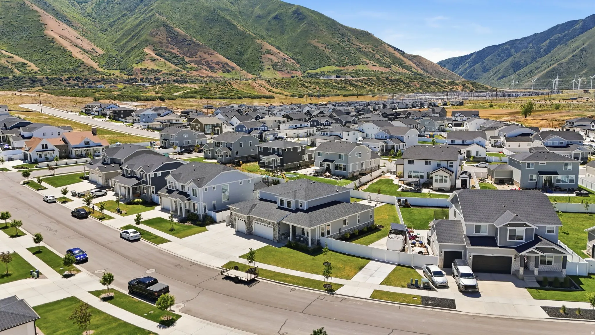 Spacious residential development featuring a collection of two-story homes with dark shingle roofs, light-toned siding, and attached garages