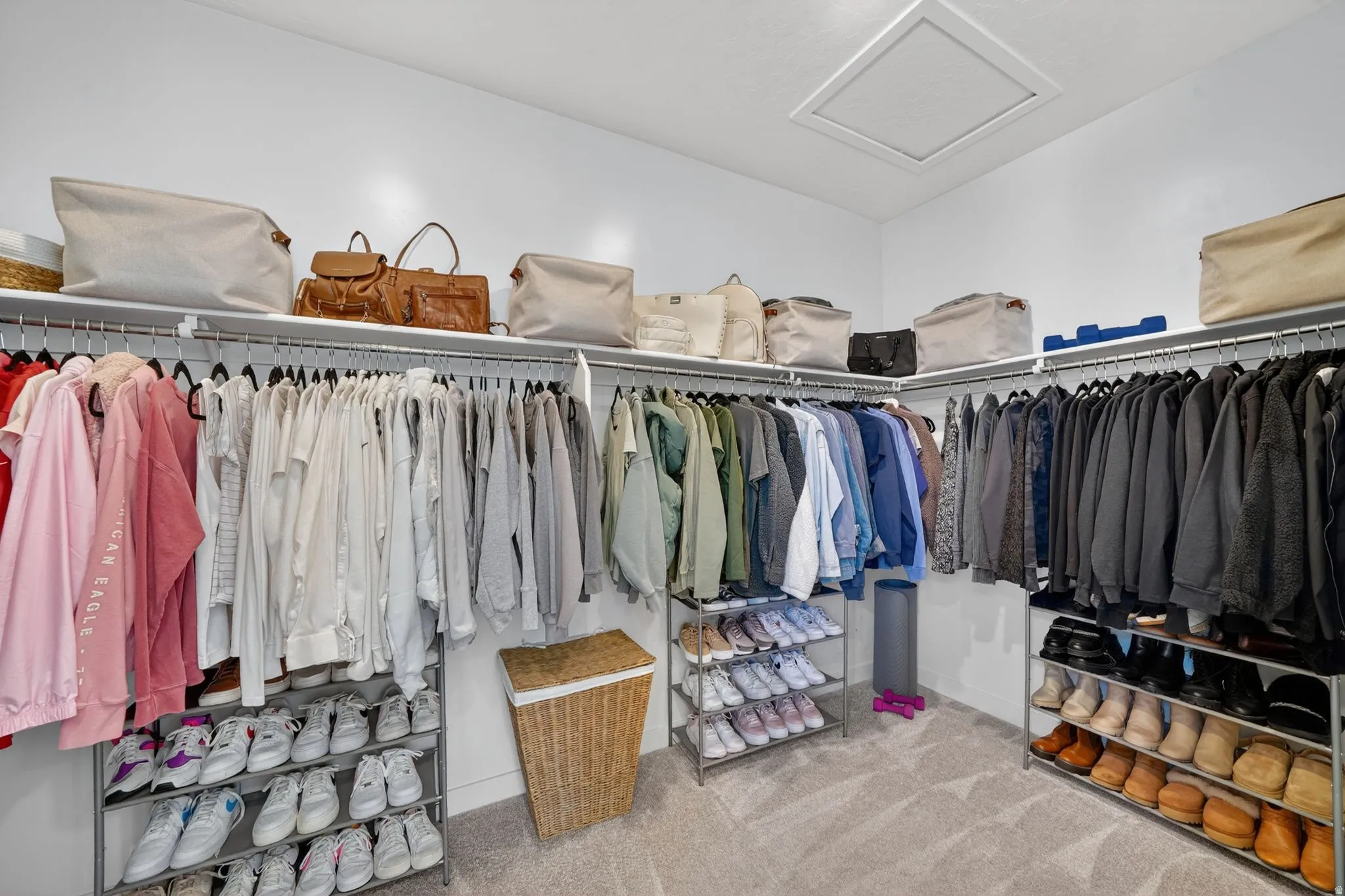 Expansive walk-in closet featuring extensive built-in shelving and hanging rods