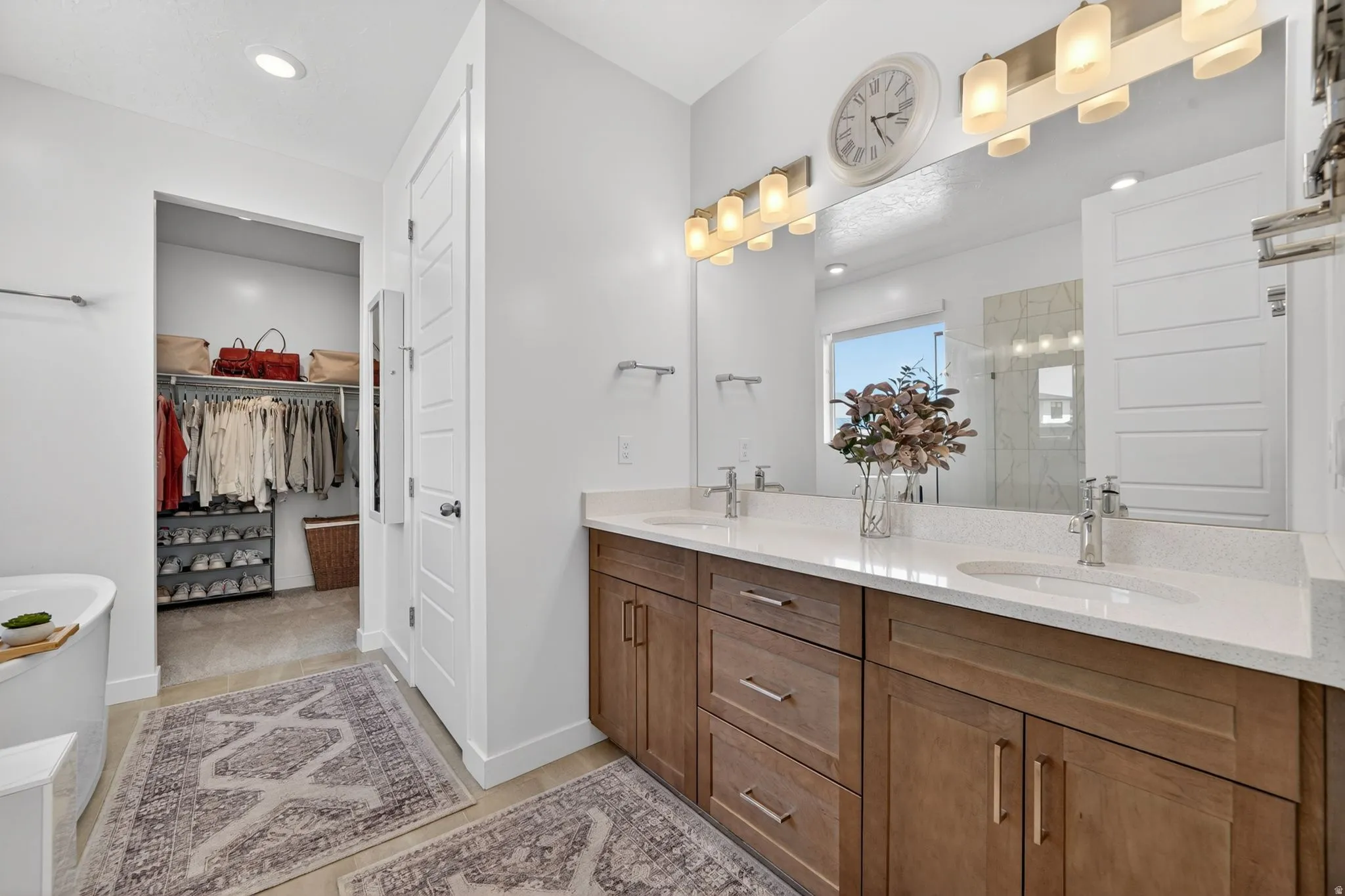 Dual wood-finish vanities with undermount sinks and light-toned countertops