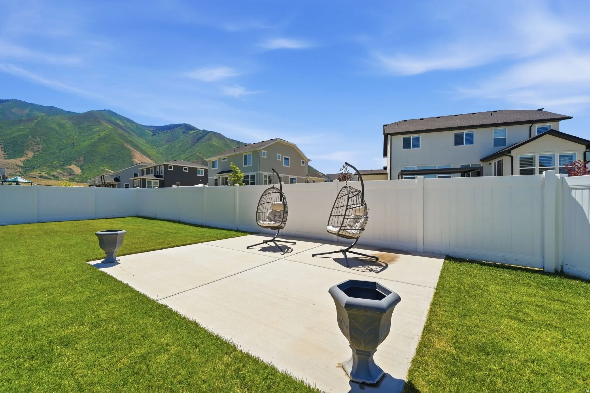 Expansive backyard featuring a lush lawn and a concrete patio