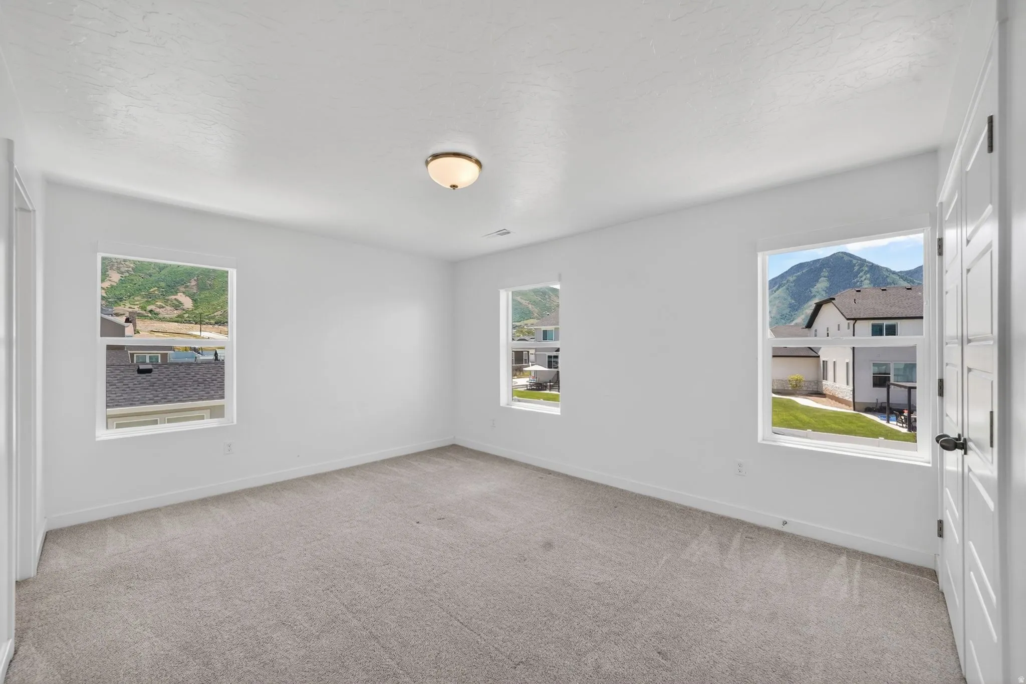Bright room featuring neutral carpet and white walls