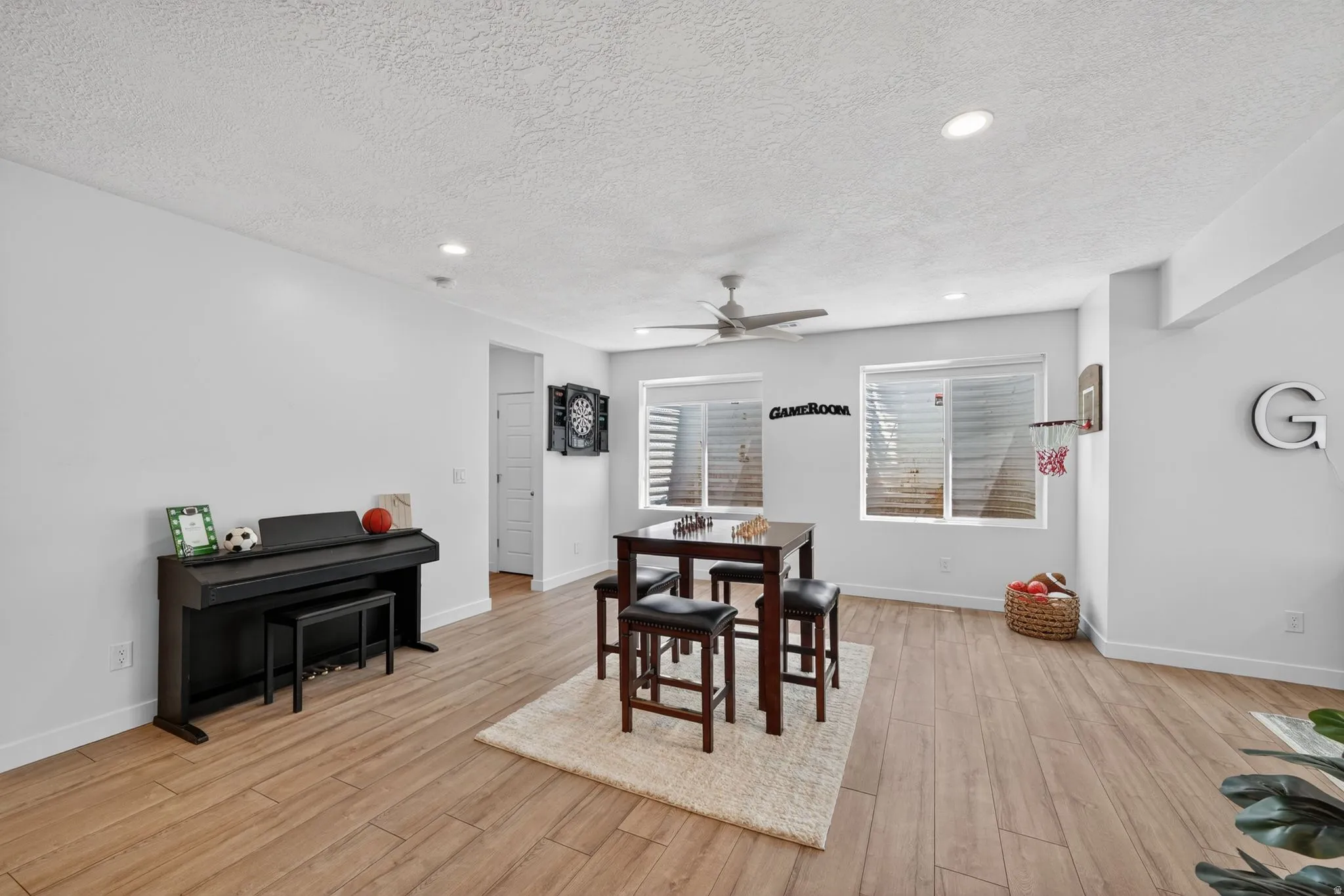 Spacious recreation room featuring wood-finish flooring, recessed lighting, and a ceiling fan