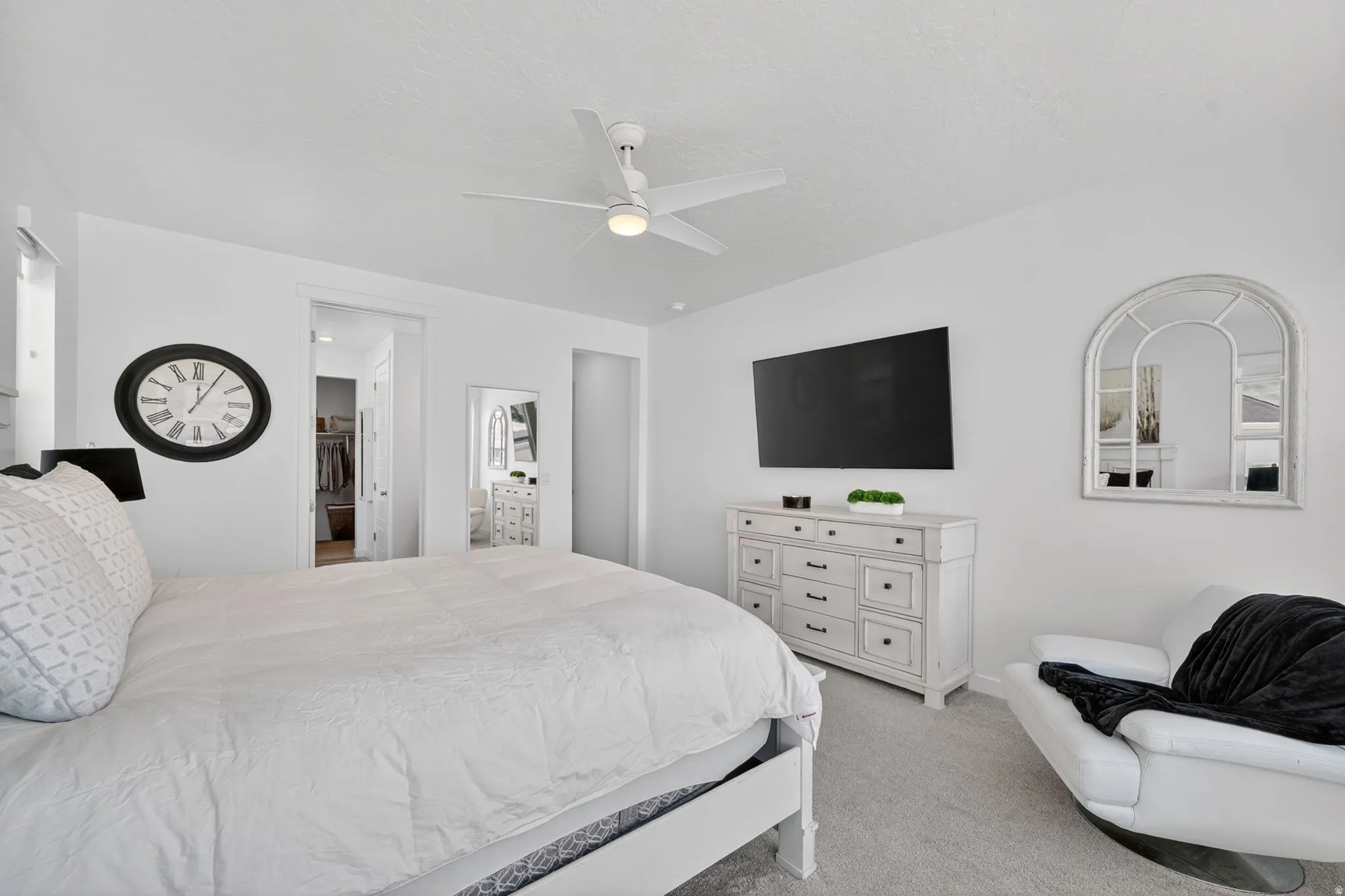 Bright bedroom featuring light-toned walls and carpeting