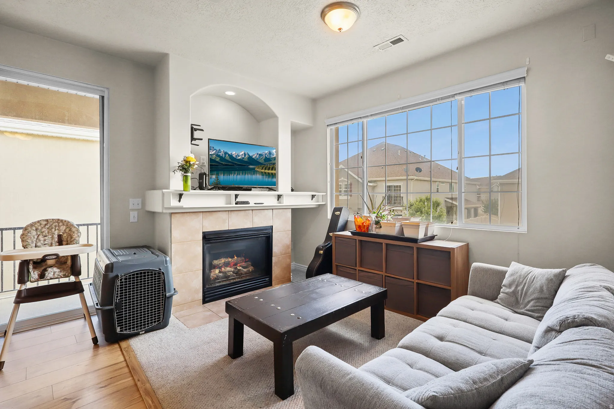 Living area featuring a fireplace with a tile surround, a built-in mantel, and an arched niche