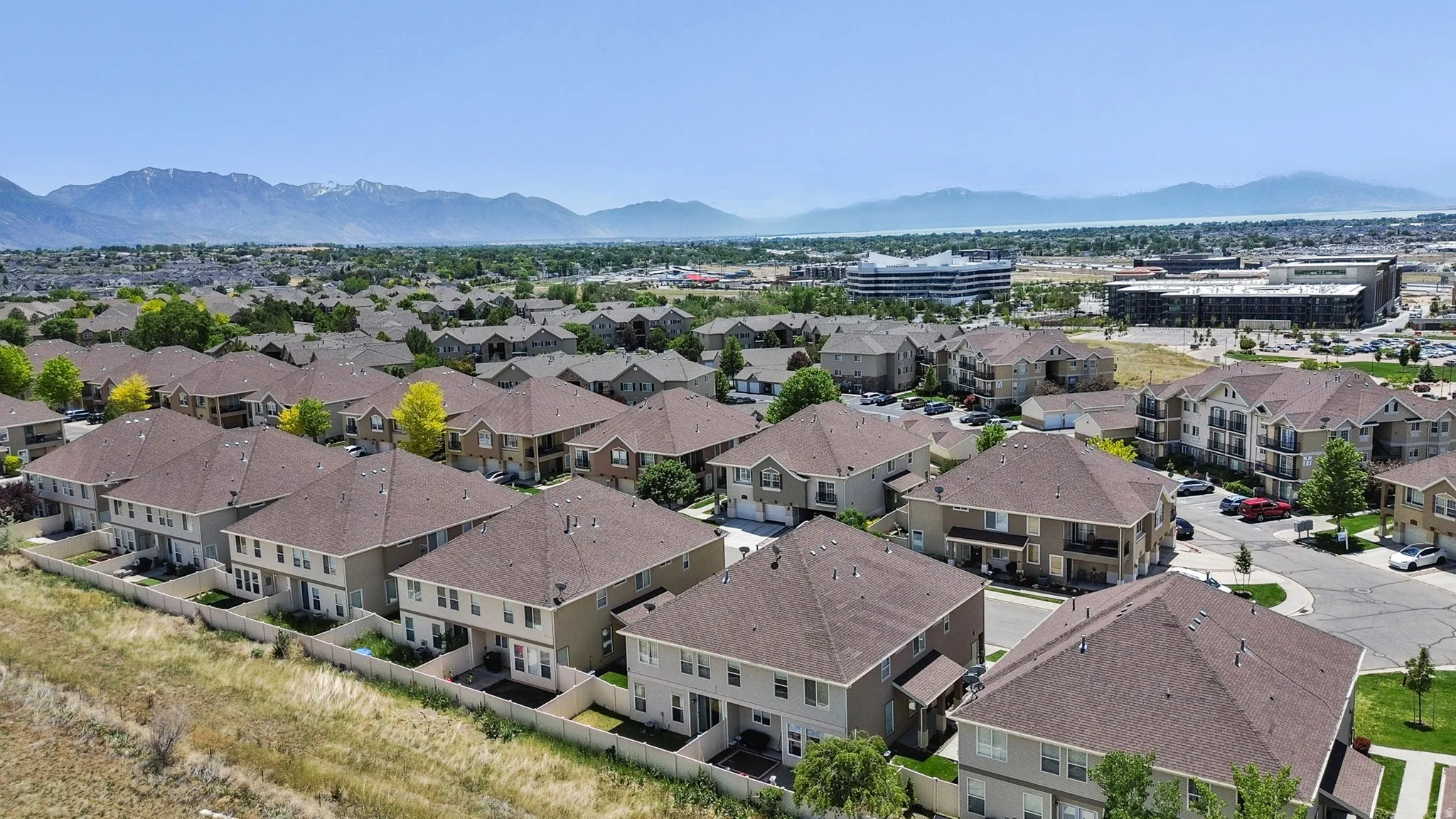 Expansive residential neighborhood featuring multi-story homes with brown shingle roofs