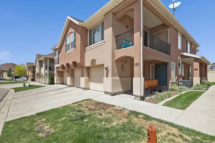 Brown stucco exterior with light trim, featuring a private balcony with black metal railings