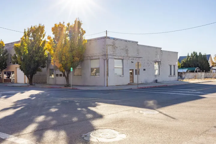 Commercial building with painted brick exterior, multiple street-facing windows, and a corner lot configuration