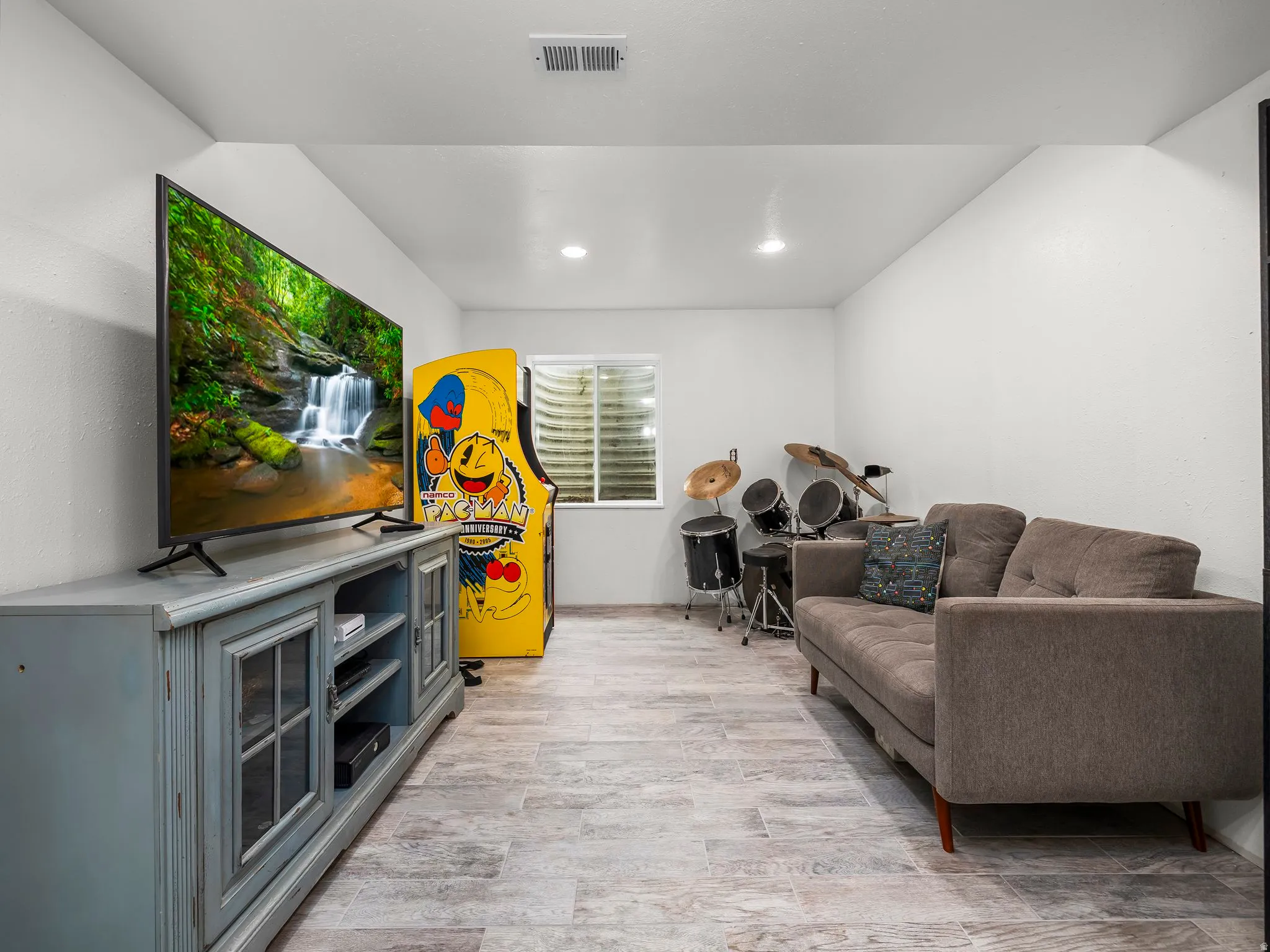Lower level living room featuring recessed lighting and a window with blinds