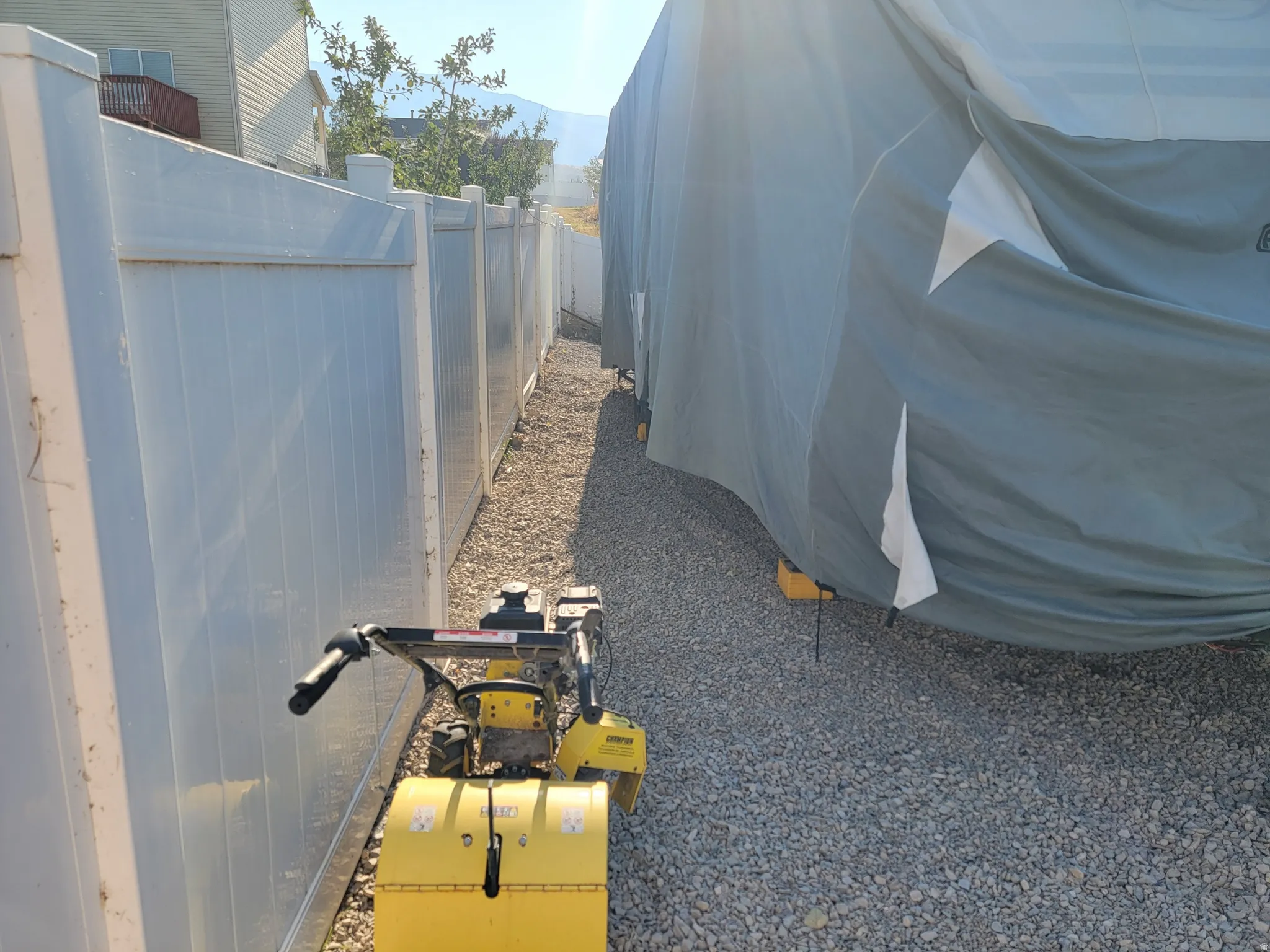 Gravel side yard featuring a privacy fence