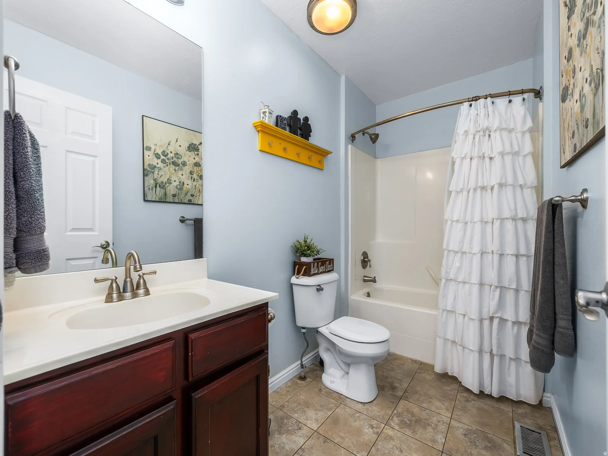 Bathroom featuring a vanity with dark wood-finish cabinetry, white countertop, and brushed nickel faucet