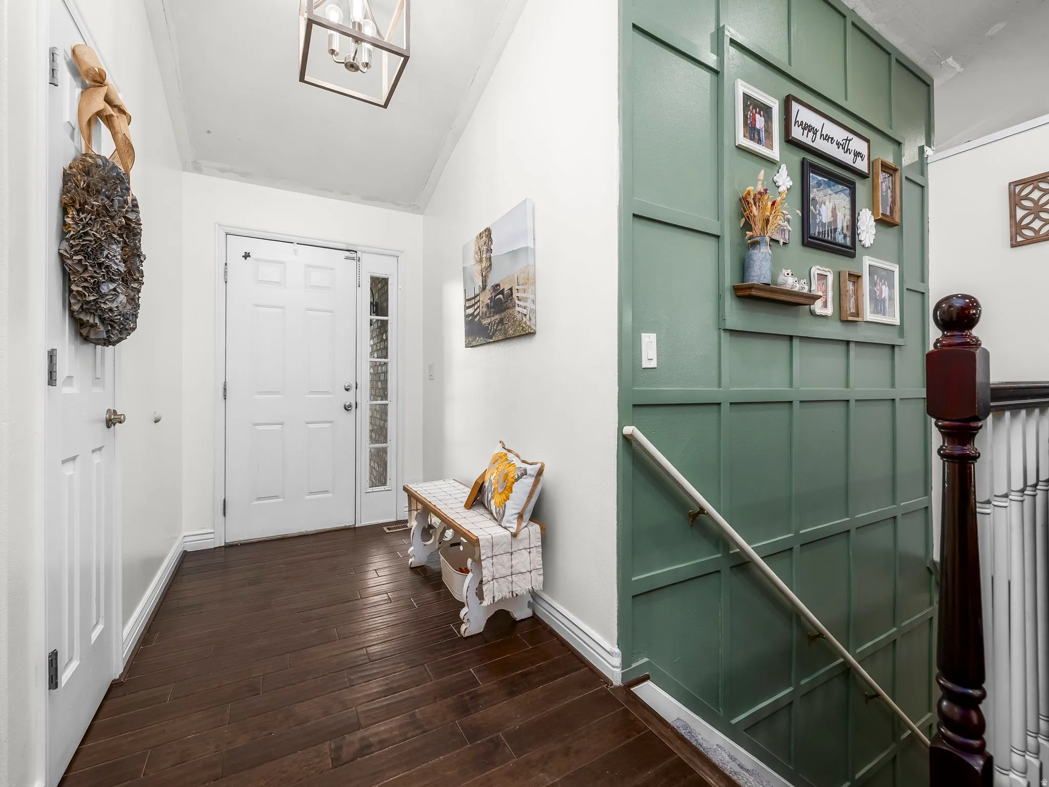 Entryway featuring dark wood-finish flooring, a white paneled door with frosted glass sidelight, a decorative wall paneling in a green hue, and a square ceiling light fixture